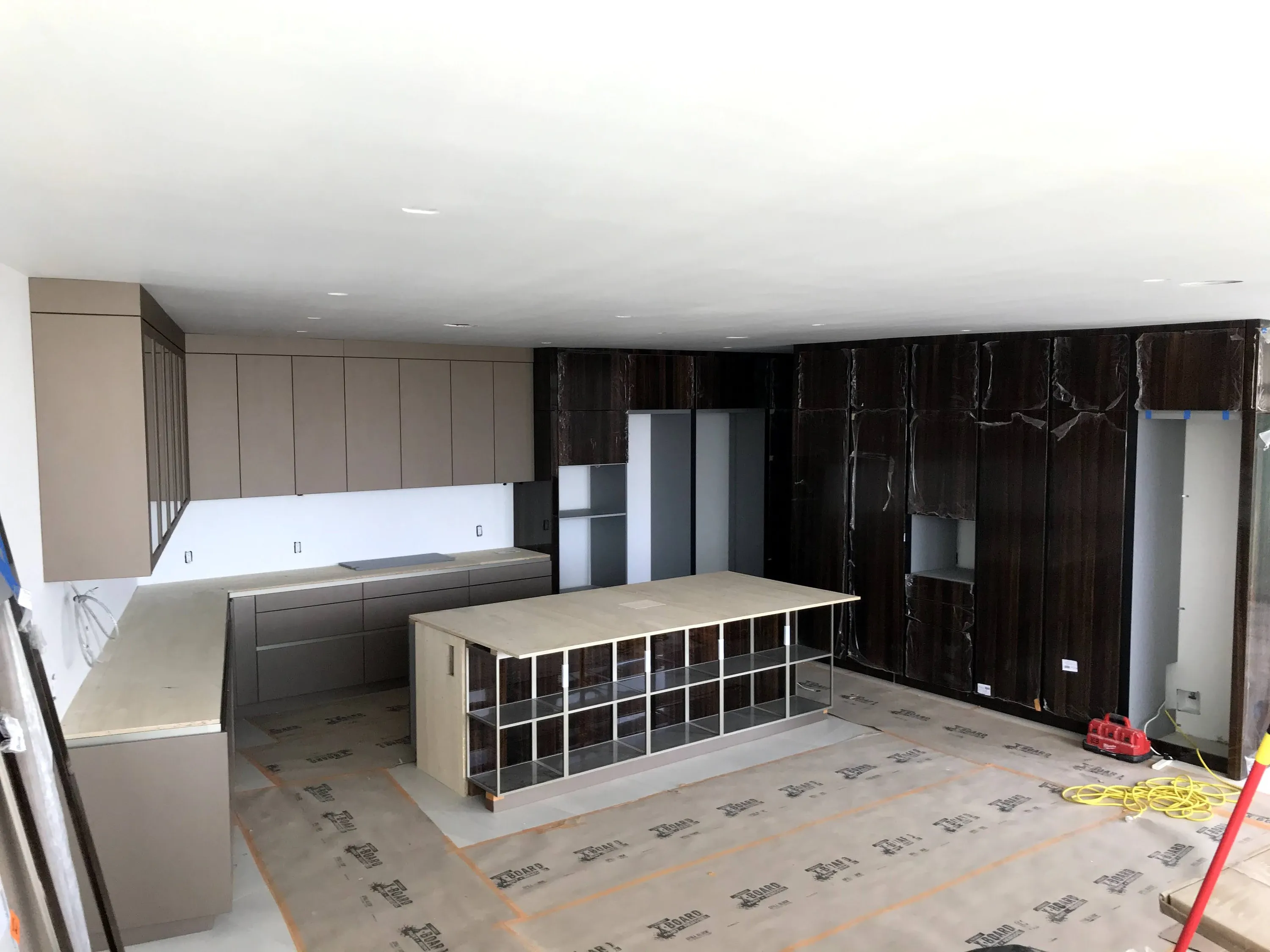 Kitchen cabinetry and stone-clad walls during installation