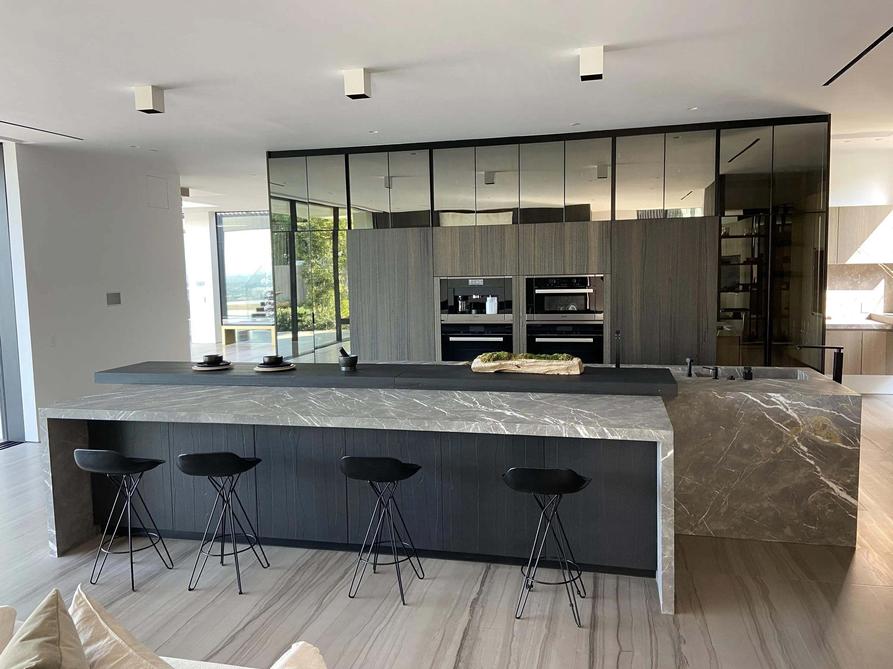 Kitchen by Nestor: stone waterfall island with a glass wine wall